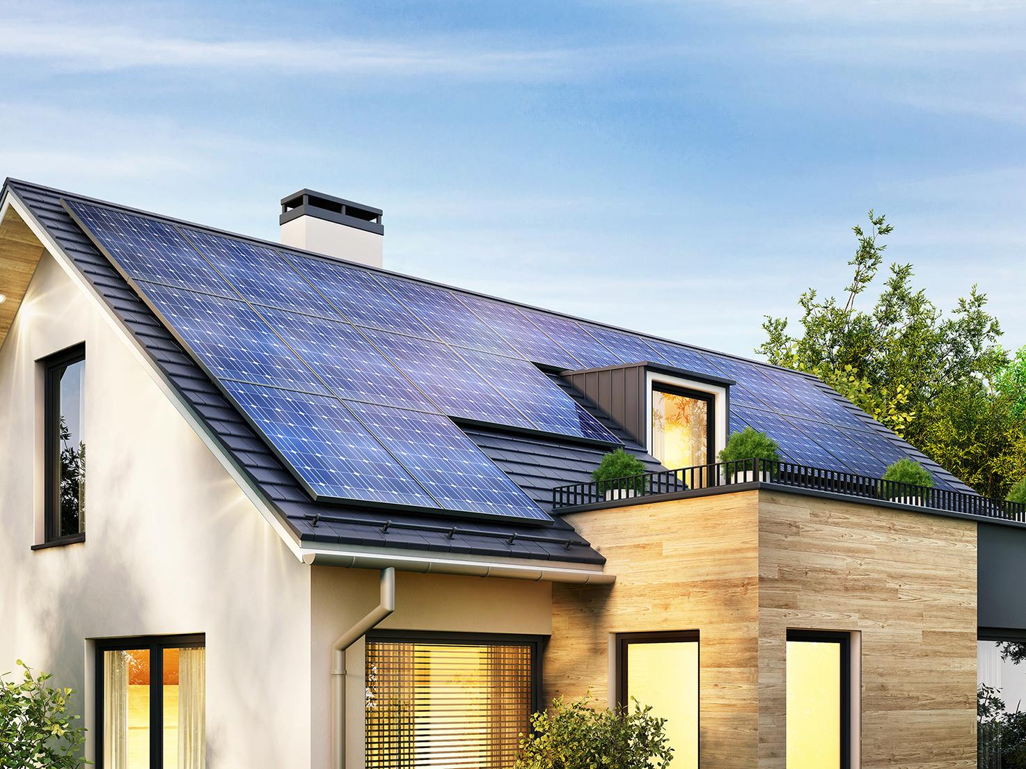 Modernes Haus mit großer Photovoltaik-Anlage auf dem Dach