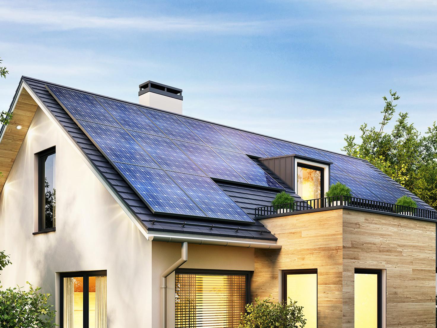 Modernes Haus mit großer Photovoltaik-Anlage auf dem Dach
