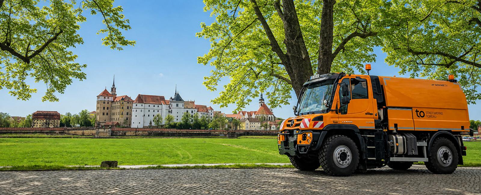 Kehrmaschine der Stadtwerke Torgau vor Schloss Hartenfels und Elbwiesen