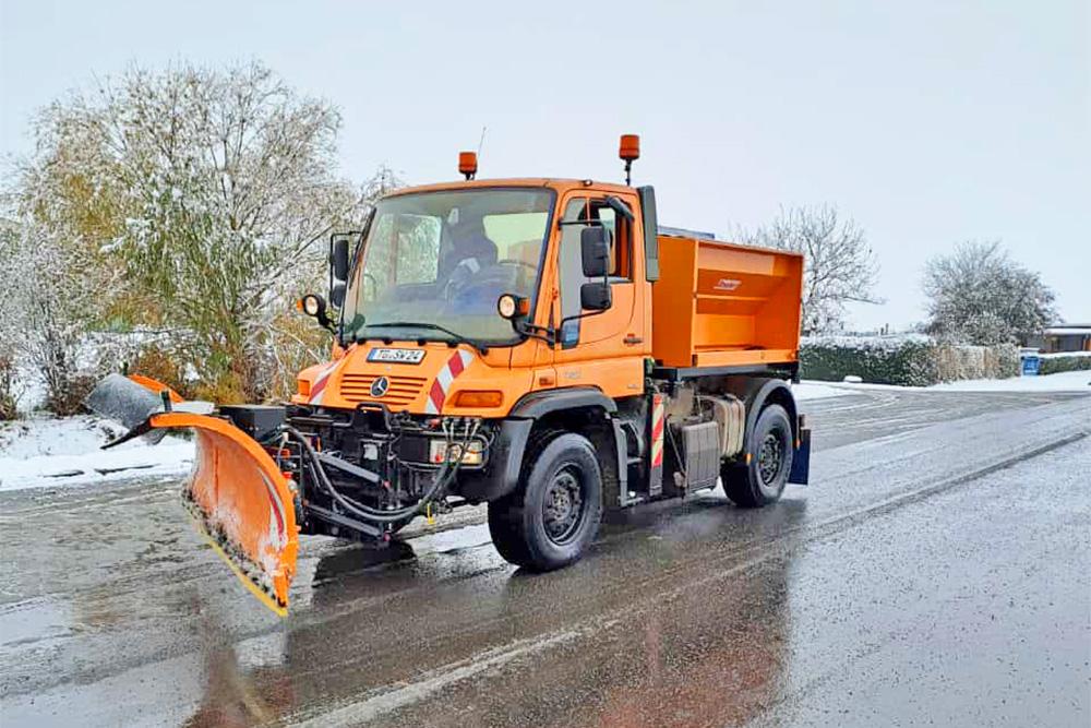 Winterdienst-Fahrzeug auf der Straße bei Schnee und Eis
