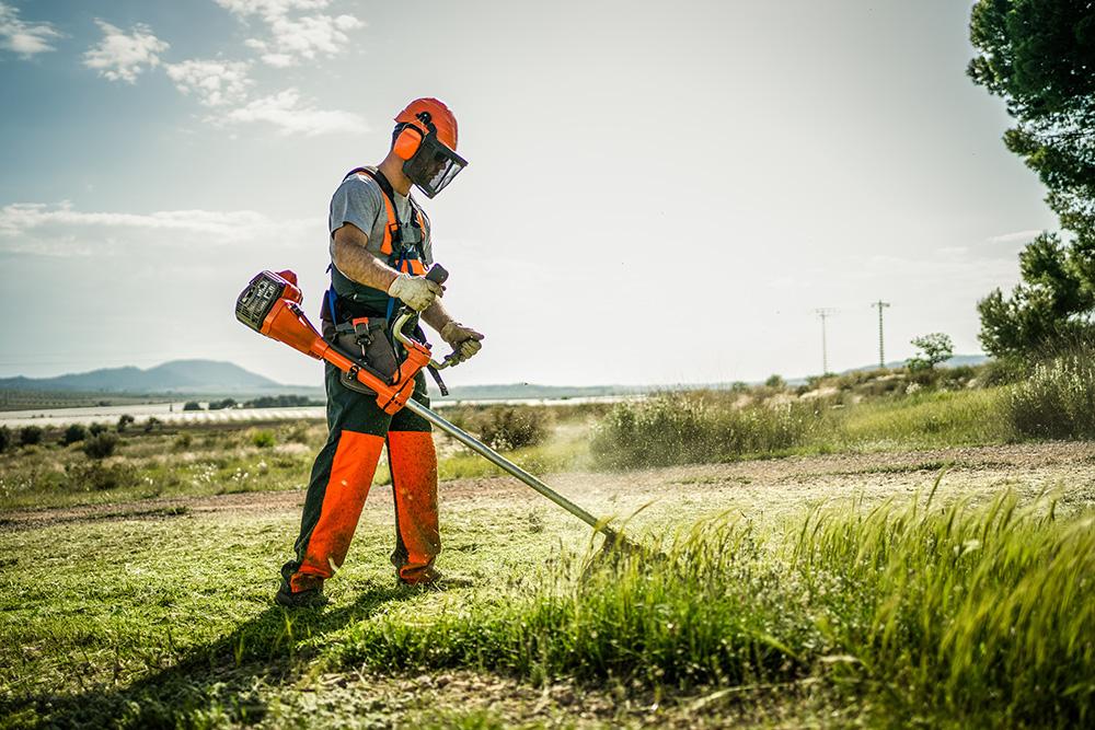 Mann mit Motorsense beim Grasschnit